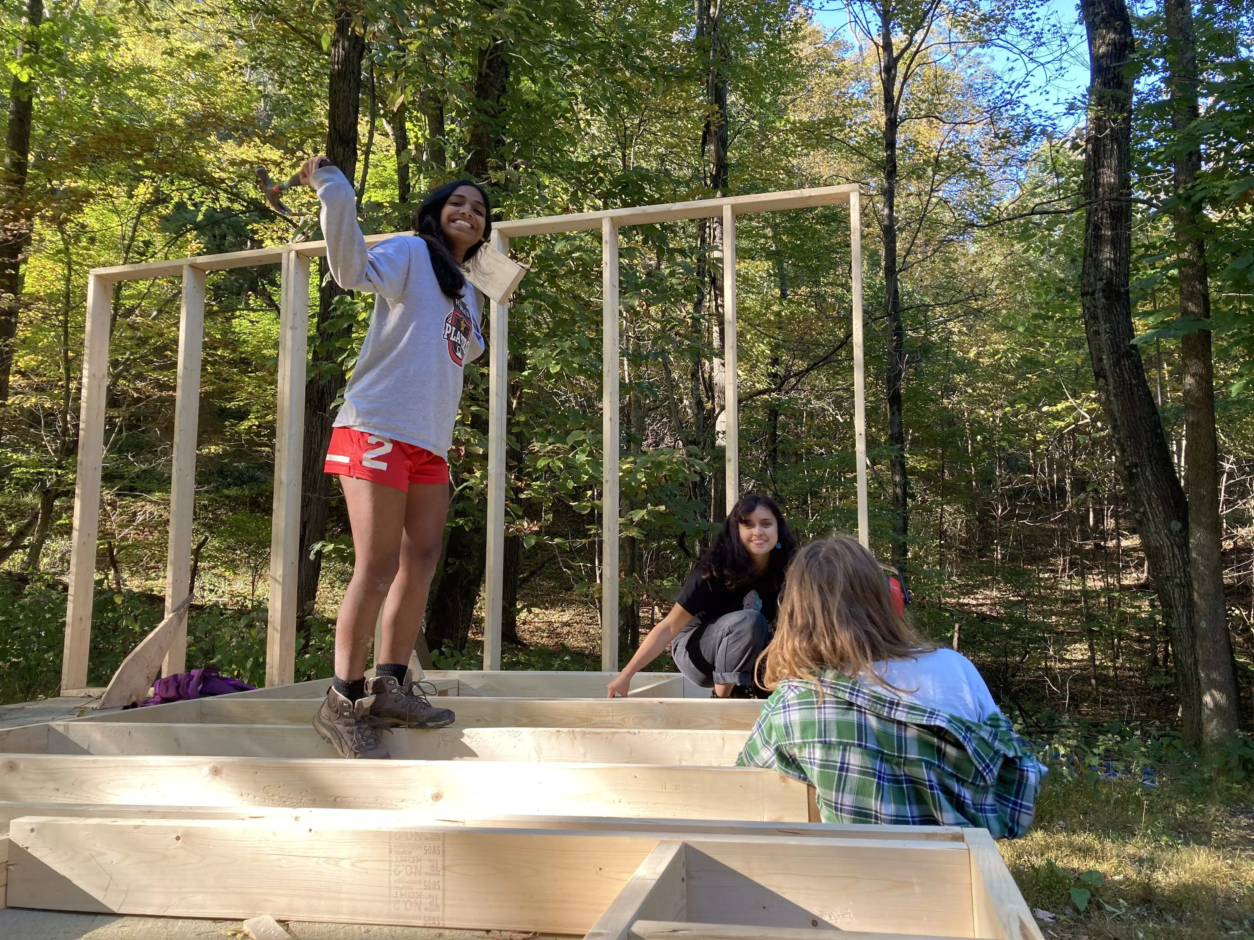 Odalys and two other people standing on the frame of a cabin!