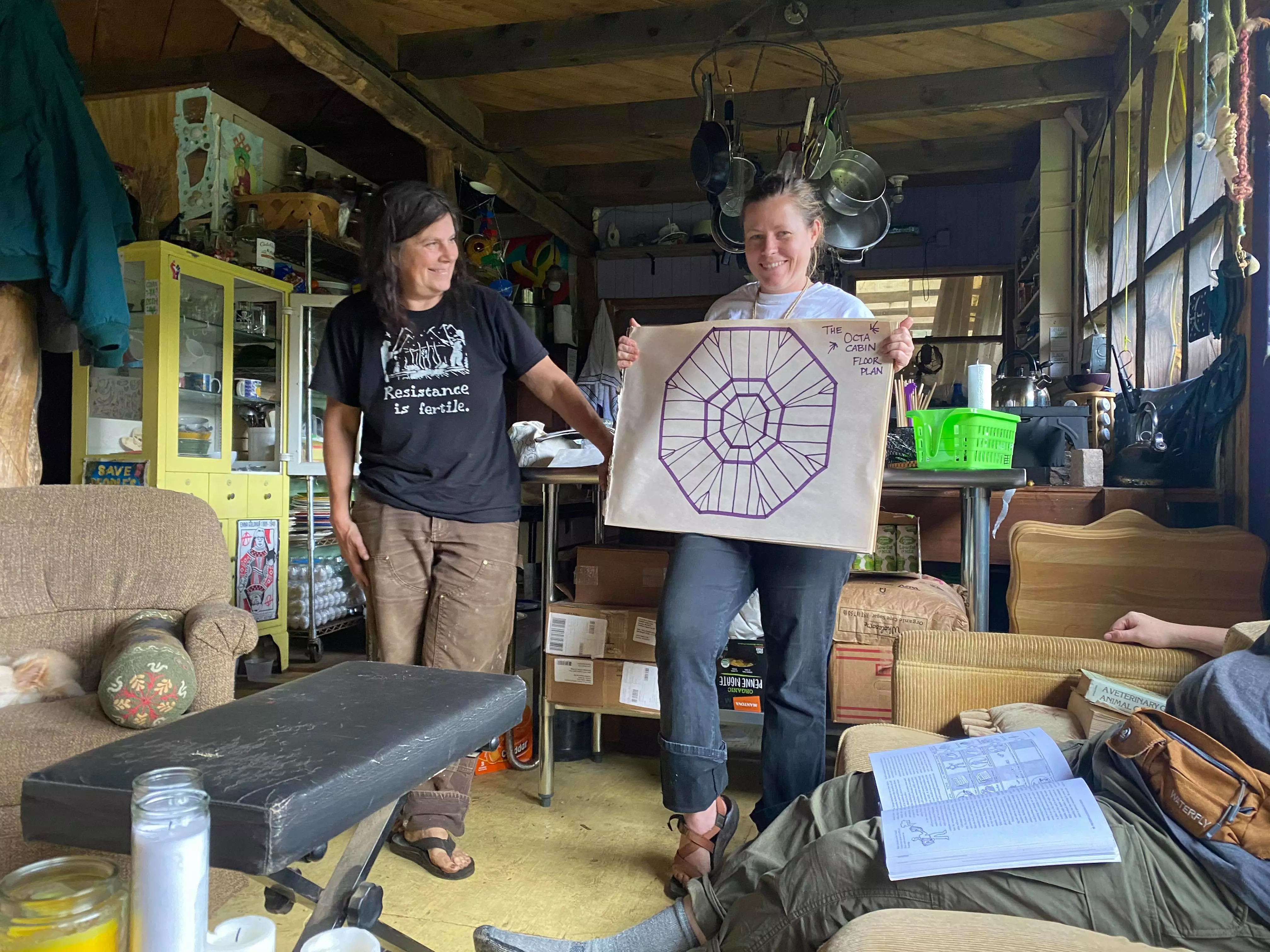 The two women who own the farm, showing off the floor plan of a cabin we're building!
