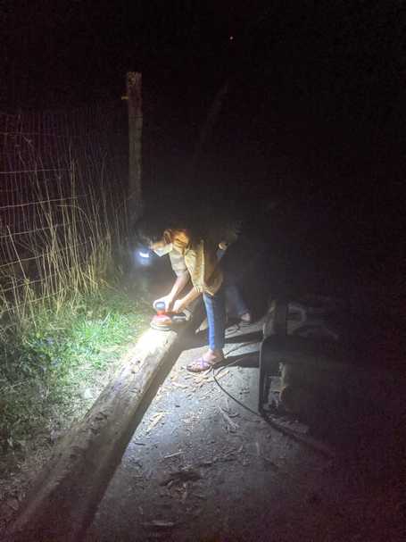 Odalys working at night, sanding down a log